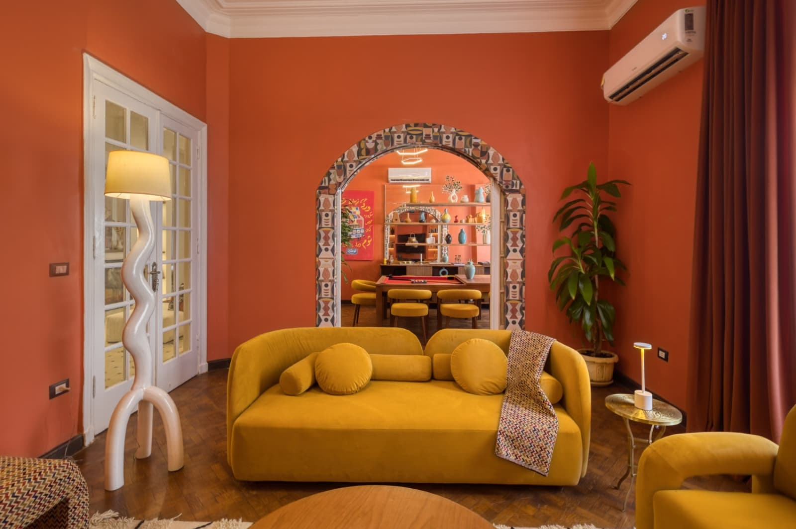 Luxurious lounge area with yellow velvet sofa and cultural design