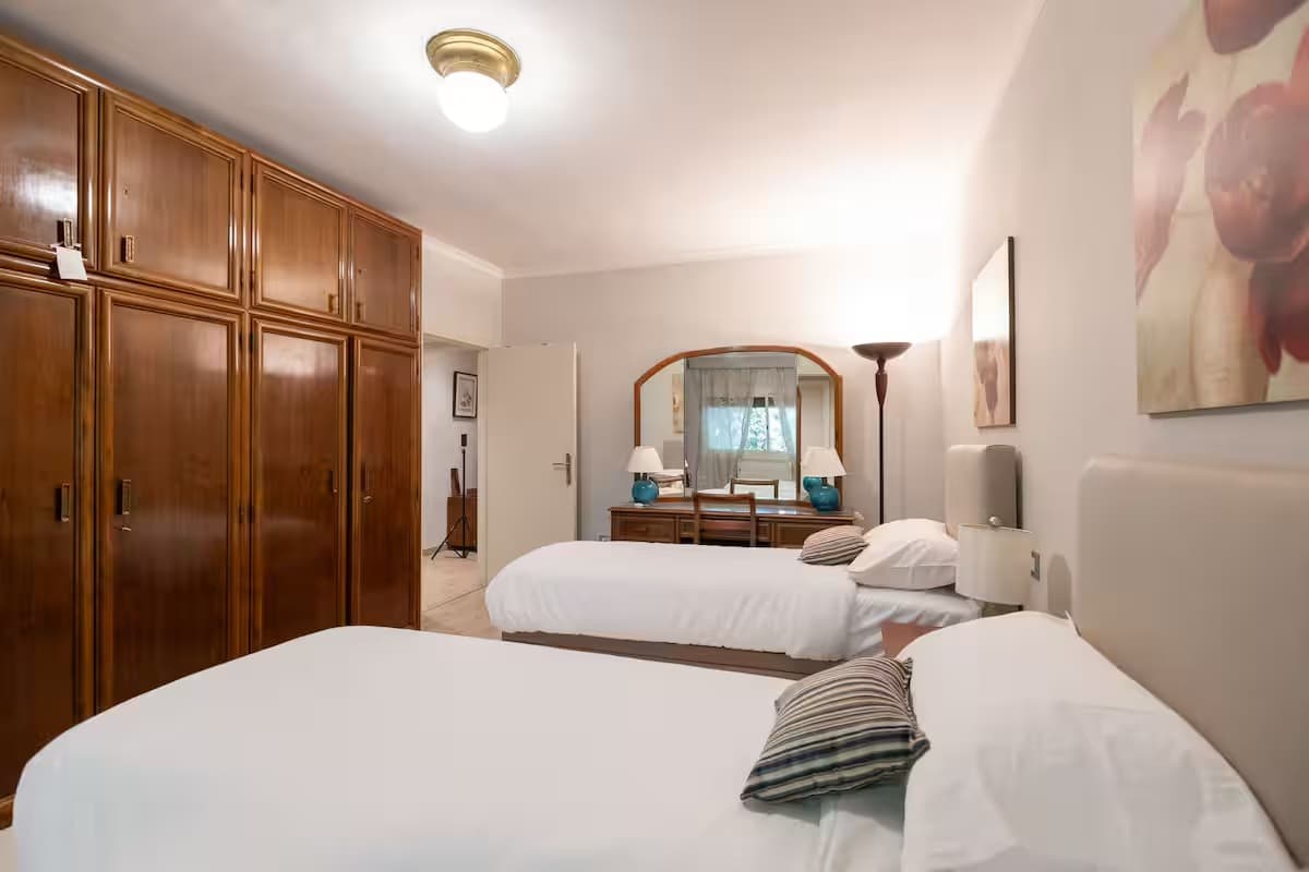 Spacious twin bedroom with built-in wardrobes and classic furnishing